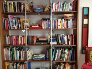 Bookcase filled with books, framed photos, and other